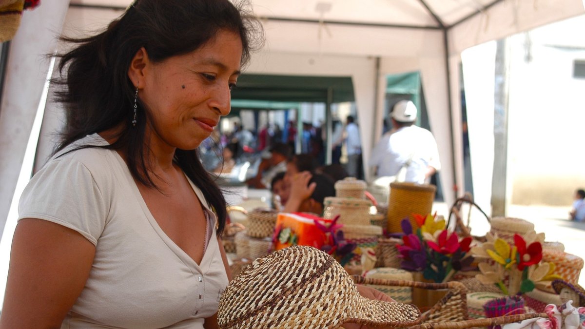 Las artesanas de la comuna de Barcelona, Santa Elena, demuestran su arte con las manos al hacer los sombreros.