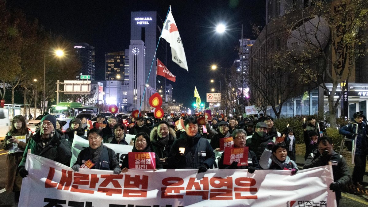 Miembros de la Confederación de Sindicatos de Corea del Sur y grupos cívicos portan una gran pancarta mientras marchan hacia la oficina presidencial durante una manifestación que pide la destitución
.