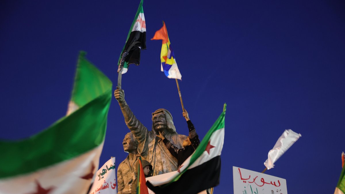 Los seguidores de la oposición siria ondean su bandera y la bandera drusa mientras celebran la toma de Damasco por parte de los rebeldes.