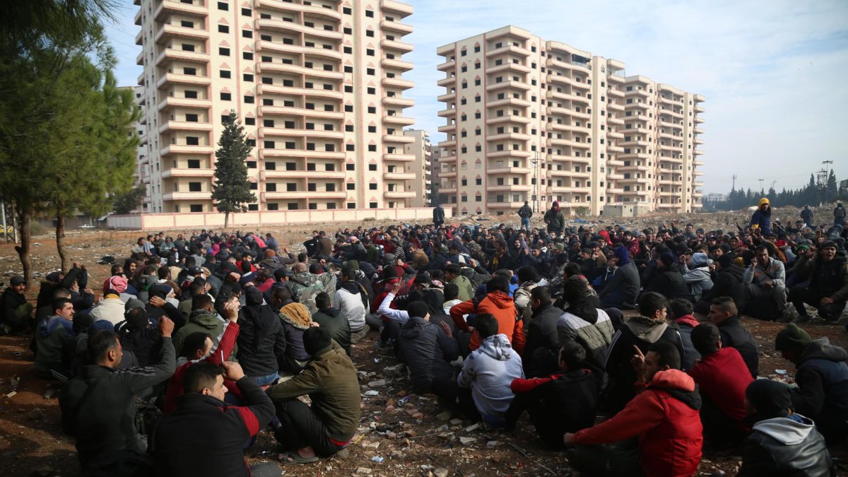 Miembros detenidos de las fuerzas de seguridad del gobierno sirio son reunidos en un campo.