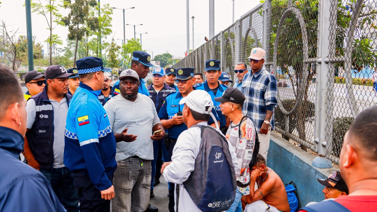 Tramitadores hablan con agentes de Control Metropolitano en los exteriores del centro de revisión vehicular ubicado en la autopista Narcisa de Jesús, norte de Guayaquil.