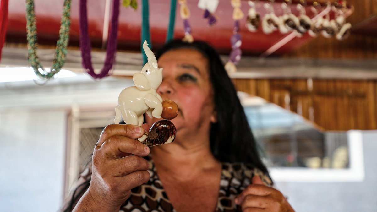 Una mujer muestra artesanías elaboradas con semillas de tagua.