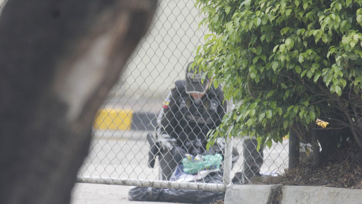 Un agente policial verifica el contenido del bulto embalado hallado en el Complejo Judicial Albán Borja, en el norte de Guayaquil.