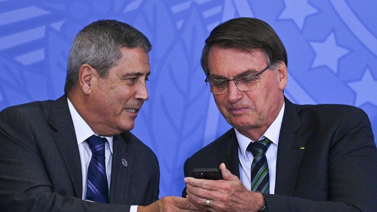 Foto de archivo, tomada el 9 de febrero de 2021, del entonces presidente de Brasil, Jair Bolsonaro (d), mientras conversa con Walter Braga Netto, quien fue ministro de la Presidencia.