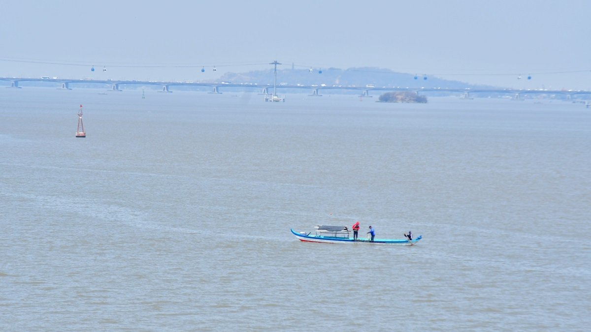 Una pequeña embarcación navega sobre el río Guayas.