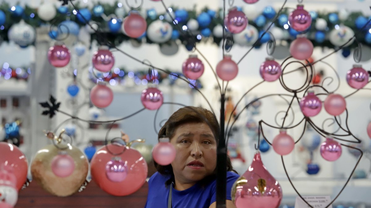 Una mujer observa esferas de vidrio soplado hechas por artesanos mexicano.