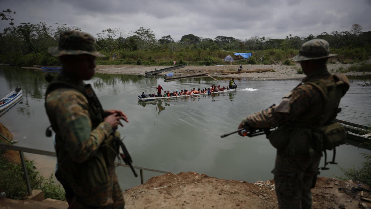 Agentes del Servicio Nacional de Fronteras vigilan la llegada de migrantes que cruzan la selva del Darién con rumbo a los Estados Unidos, en Bajo Chiquito (Panamá).