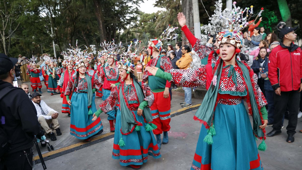Integrantes de una comparsa bailan música navideña durante el primer día de novenas este lunes, en Bogotá (Colombia).
