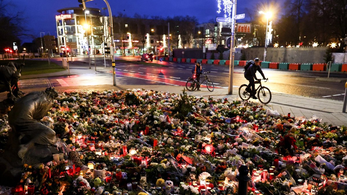 Velas y flores en el lugar de duelo frente a la iglesia de San Juan tras el ataque con un vehículo en el mercado navideño de Magdeburgo, Alemania, el 22 de diciembre de 2024.