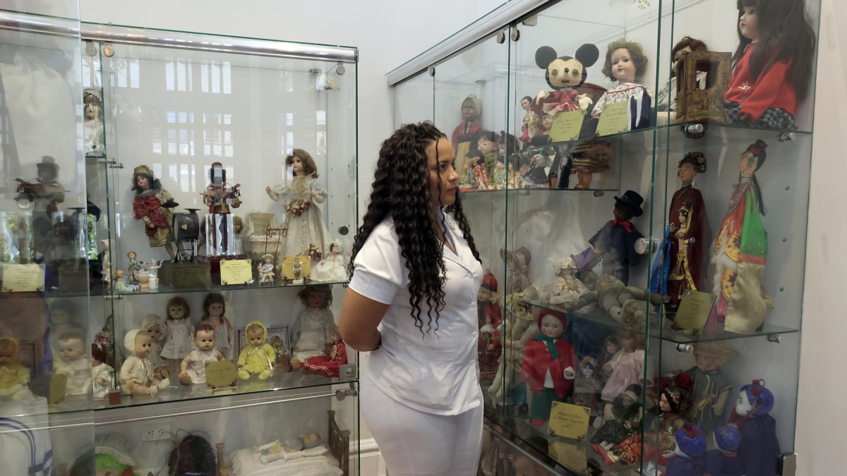 otografía del 15 de diciembre de 2024 de una mujer observando la colección de la casa de muñecas 'Un momento de fantasía' en Cartagena (Colombia).
