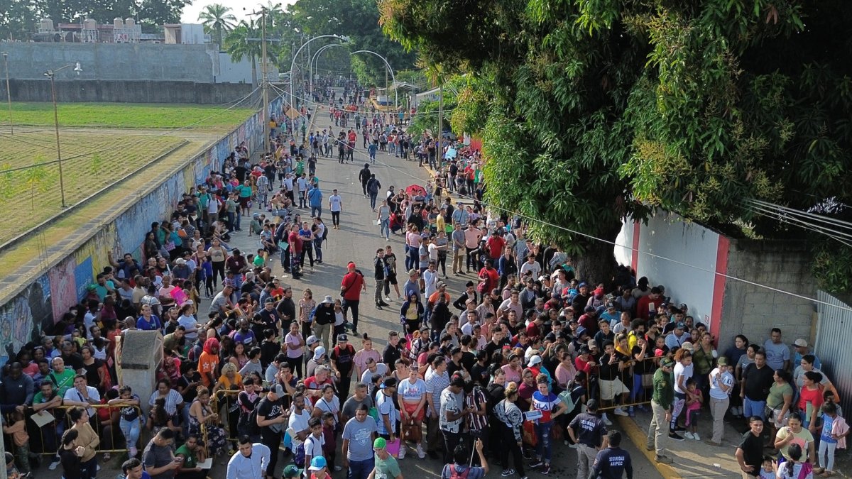 Varios migrantes aparecen haciendo fila el 22 de diciembre de 2024, para realizar sus procesos migratorios, en el municipio de Tapachula en Chiapas (México).