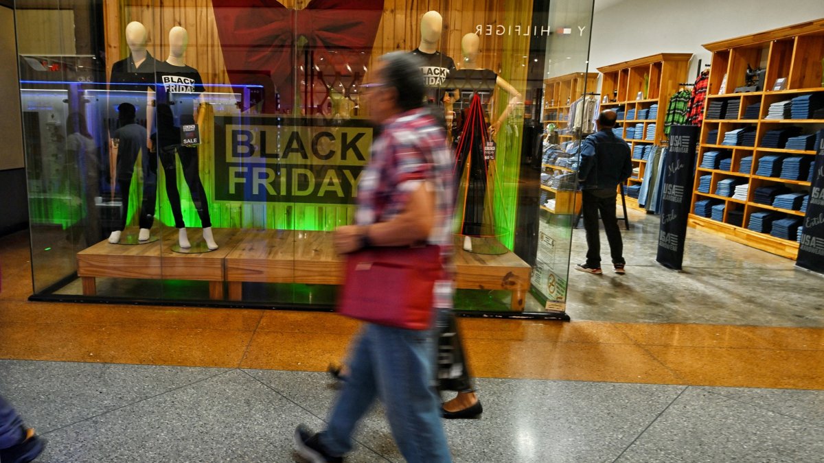 La gente camina frente a una tienda durante una venta del Viernes Negro en Caracas el 29 de noviembre de 2024.