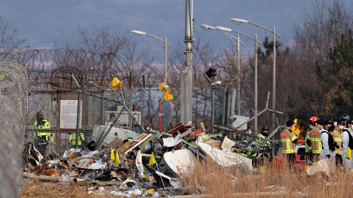 Se ven restos del avión de Jeju Air en el aeropuerto internacional de Muan en Muan, a 288 kilómetros al suroeste de Seúl, Corea del Sur, este domingo 29 de diciembre de 2024.