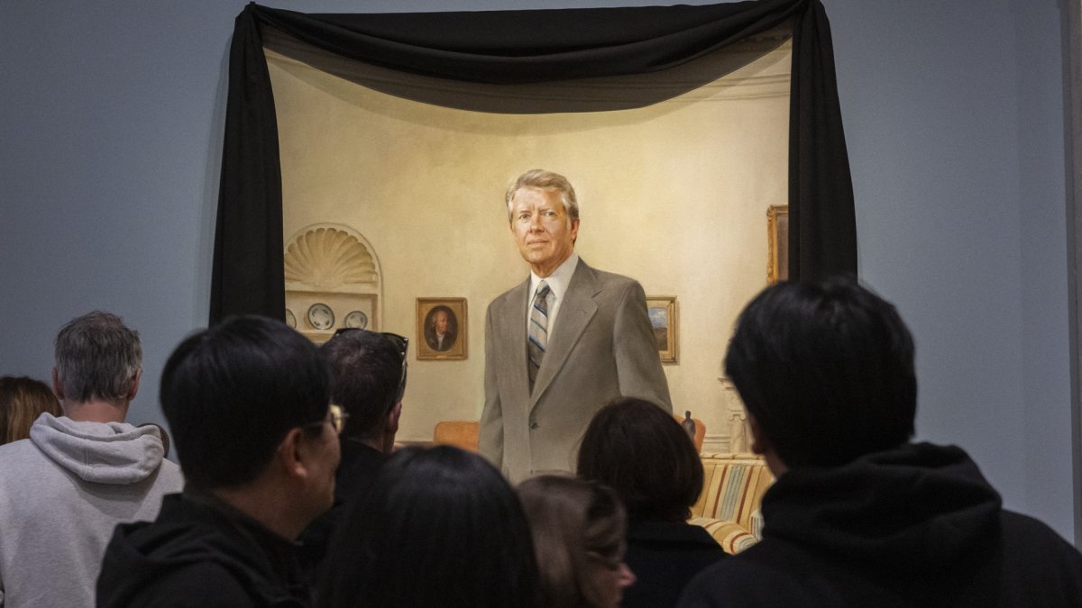 Los visitantes de la Galería Nacional de Retratos del Smithsonian contemplan un retrato del expresidente estadounidense Jimmy Carter en la Oficina Oval de la Casa Blanca.