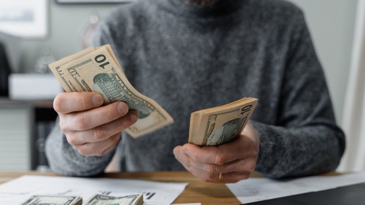 Plan. Una persona organiza sus finanzas, separa el dinero con el que debe pagar deudas.