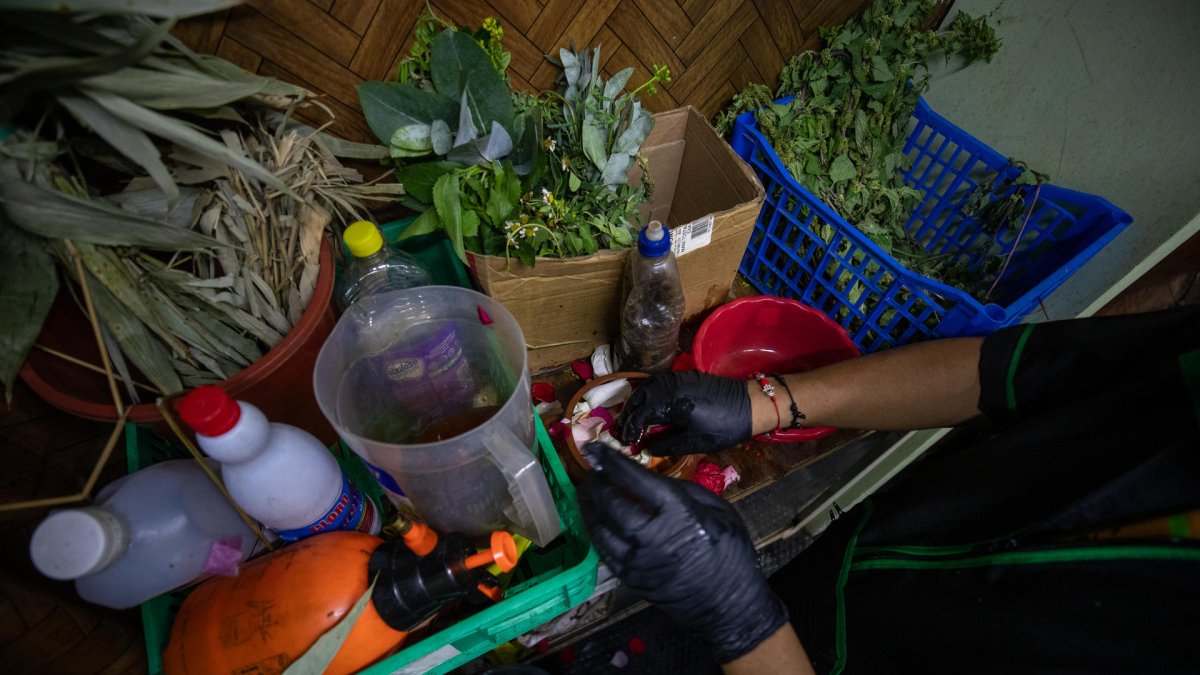 El curandero ecuatoriano Ismael mezcla hierbas para un ritual para recibir el nuevo año 2025 este martes 31 de diciembre, en un local de curanderos en Quito (Ecuador).