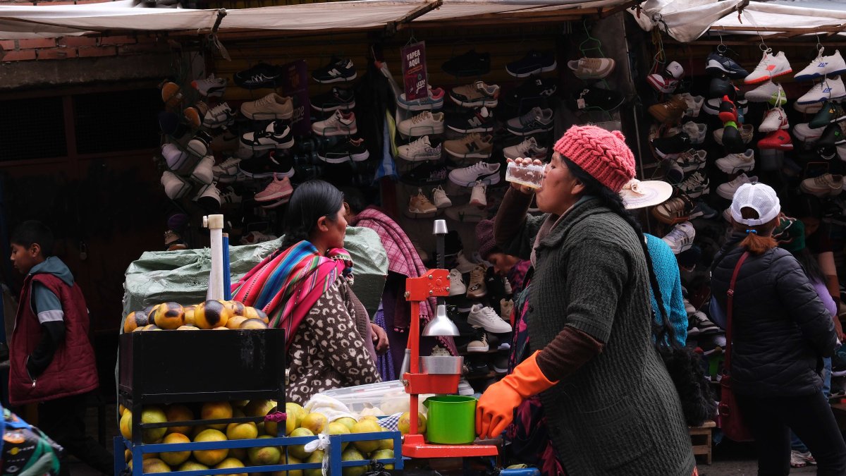 Fotografía del 20 de diciembre de 2024 de una mujer aimara vendiendo jugos naturales en una calle de La Paz (Bolivia). 
