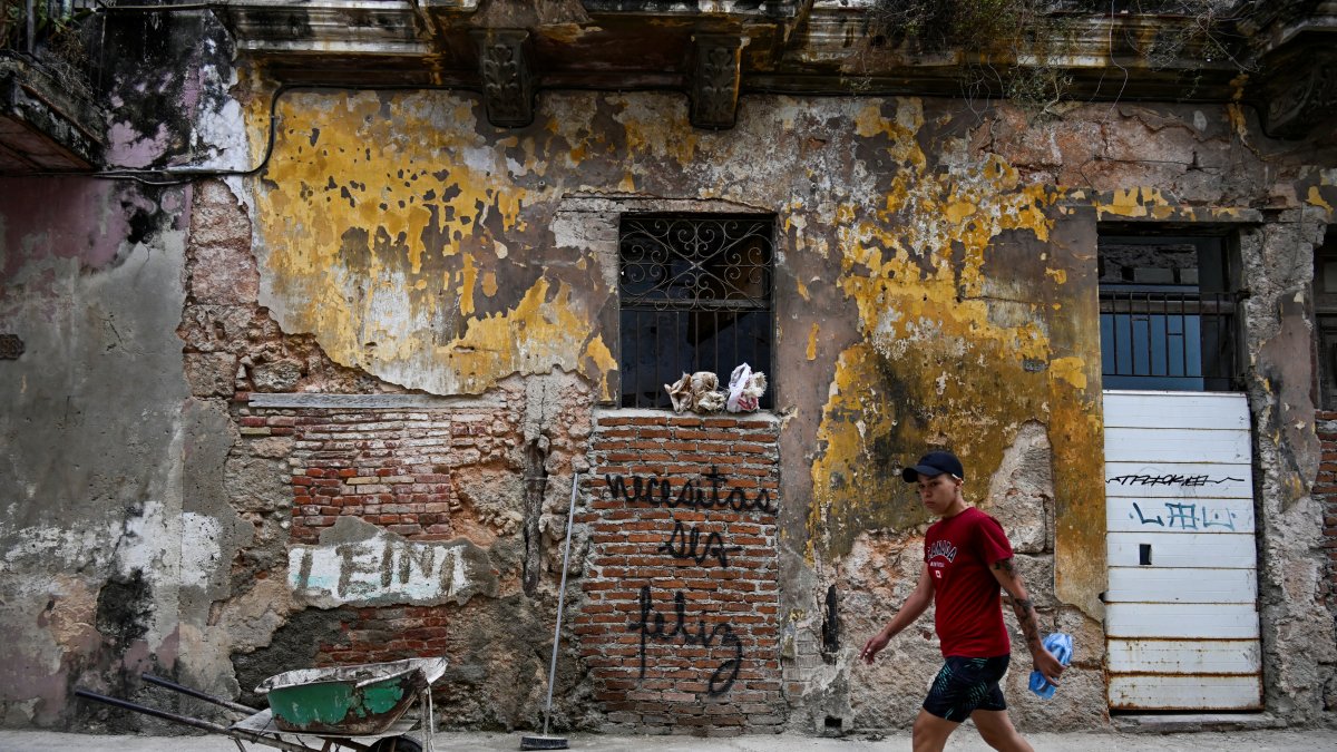 Un hombre pasa junto a un grafiti que dice 