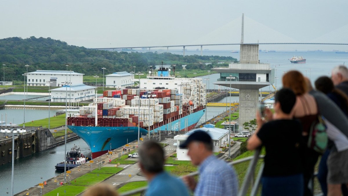 Vía. Turistas ven el paso de un buque que lleva contenedores de varios productos por el Canal de Panamá.