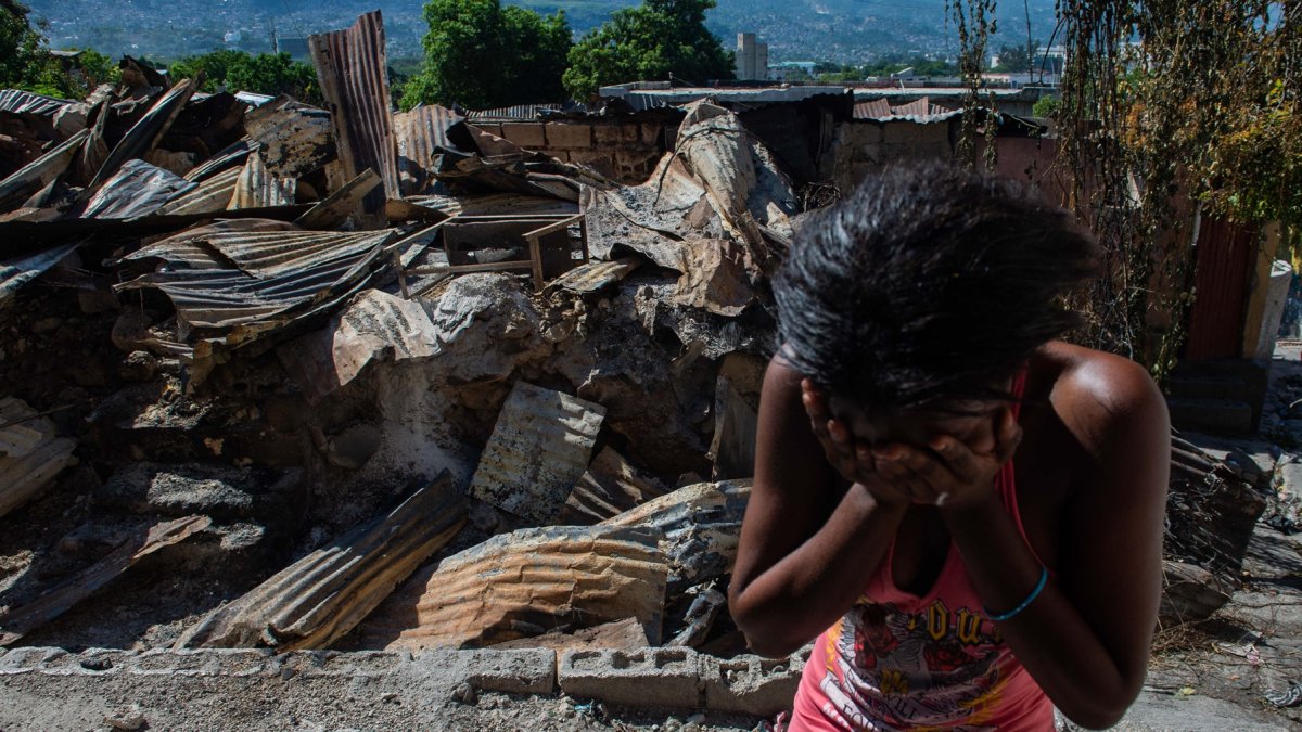 Una mujer llora afuera de su casa después de que bandas armadas la incendiaran en el barrio de Post Marchand de Puerto Príncipe el 17 de diciembre de 2024.