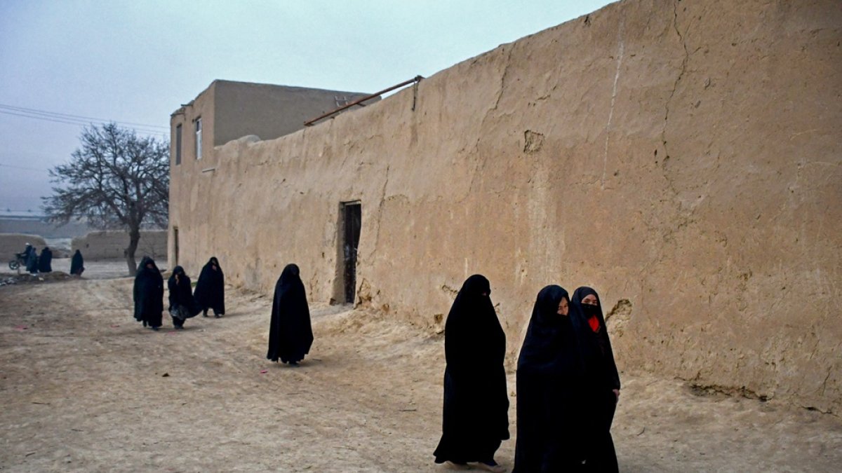 Mujeres afganas caminan por una carretera temprano en la mañana en las afueras de Mazar-i-Sharif el 30 de diciembre de 2024.