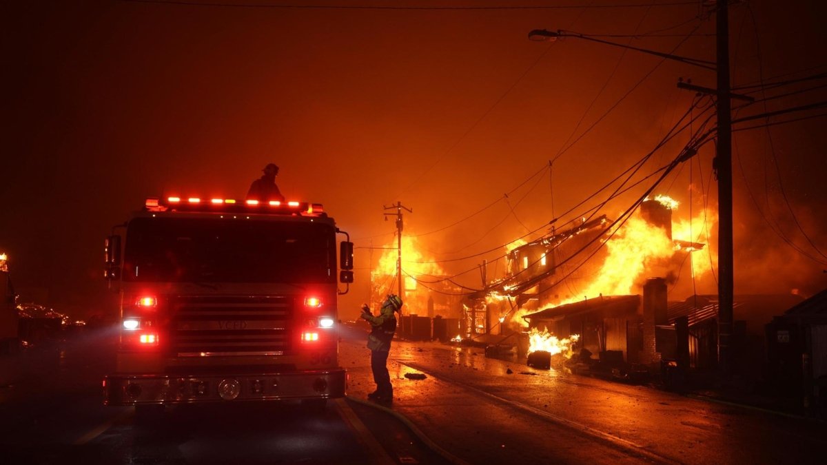 Los bomberos trabajan mientras el incendio forestal de 'Palisades' quema varias estructuras a lo largo de la carretera de la Costa del Pacífico en Malibú, California.
