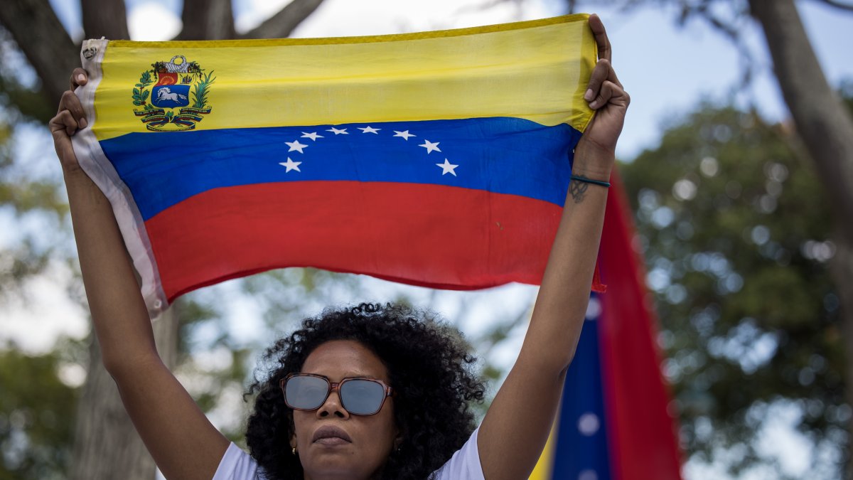 Una mujer sostiene una bandera de Venezuela. El 10 de enero está previsto la posesión presidencial.