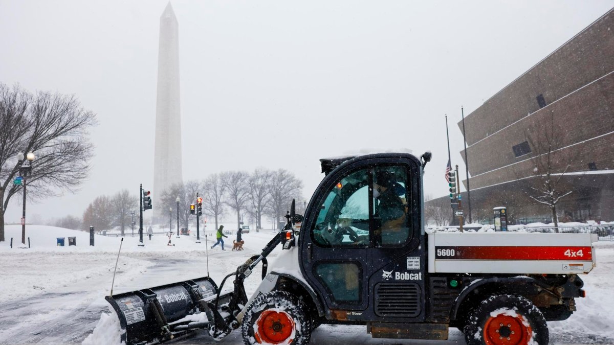 Una máquina quitanieves limpia una acera cerca del Monumento a Washington en la Explanada Nacional en Washington, DC, EE. UU.