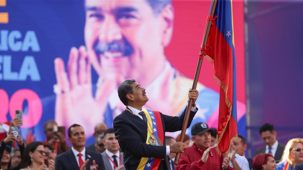 El líder chavista Nicolás Maduro ondea una bandera en un acto este viernes 10 de enero, en Miraflores a unos 74 km de Caracas (Venezuela).