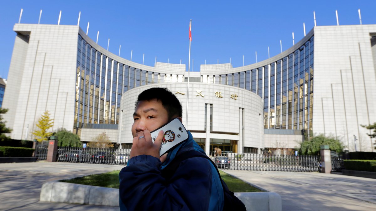 Entidad. Una persona camina cerca de la sede del Banco Popular de China.