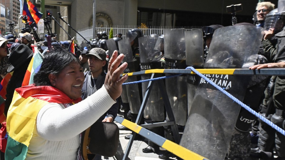 Una partidaria del expresidente Evo Morales, hace un gesto frente a agentes de la policía antidisturbios durante la marcha 