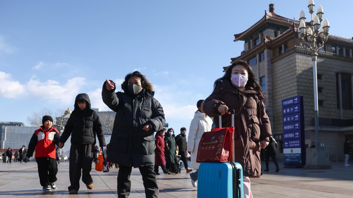 Un grupo de personas camina por los alrededores de la estación de trenes de Pekín, China.