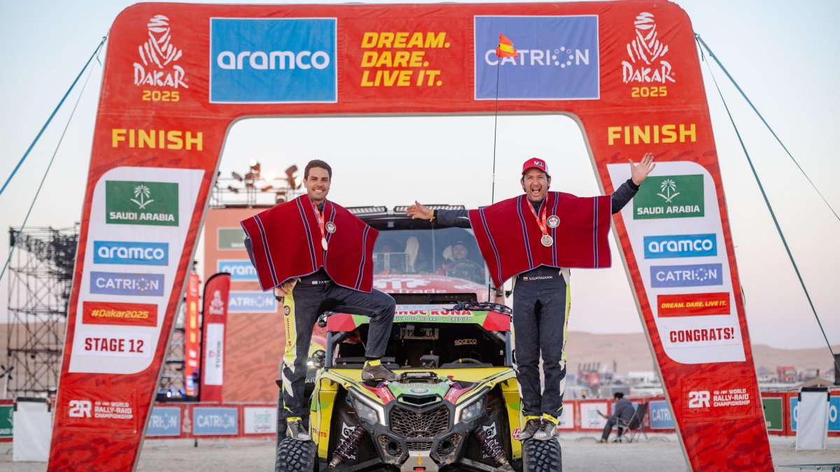 El ecuatoriano Sebastián Guayasamín (d) y su copiloto, el argentino Fernando Acosta, posan orgullos en la linea de meta con sus ponchos tras terminar el Dakar.