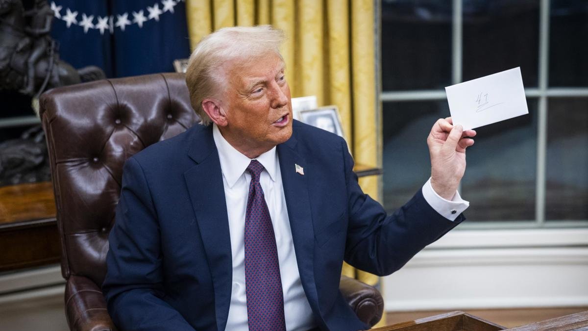 El presidente Donald Trump sostiene una carta que le dejó el exmandatario Joe Biden, este lunes 20 de enero del 2025.