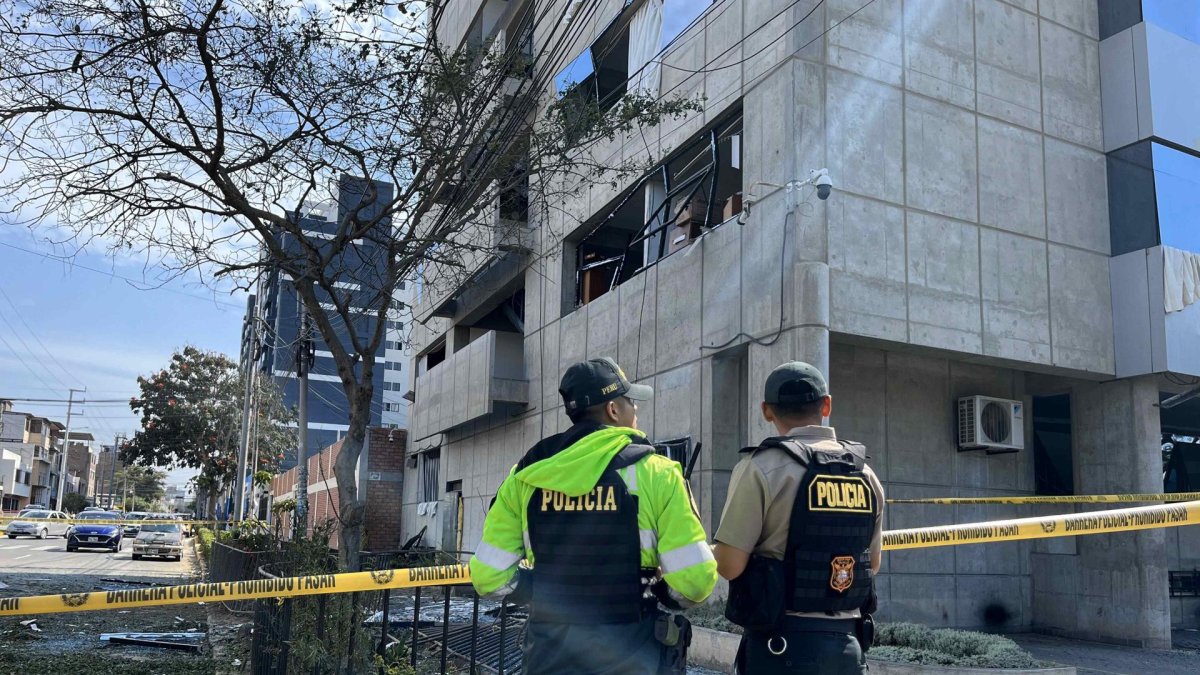Integrantes de la policía custodian el lugar donde detono un explosivo frente a la sede de la Fiscalía este lunes, en la ciudad de Trujillo (Perú).
