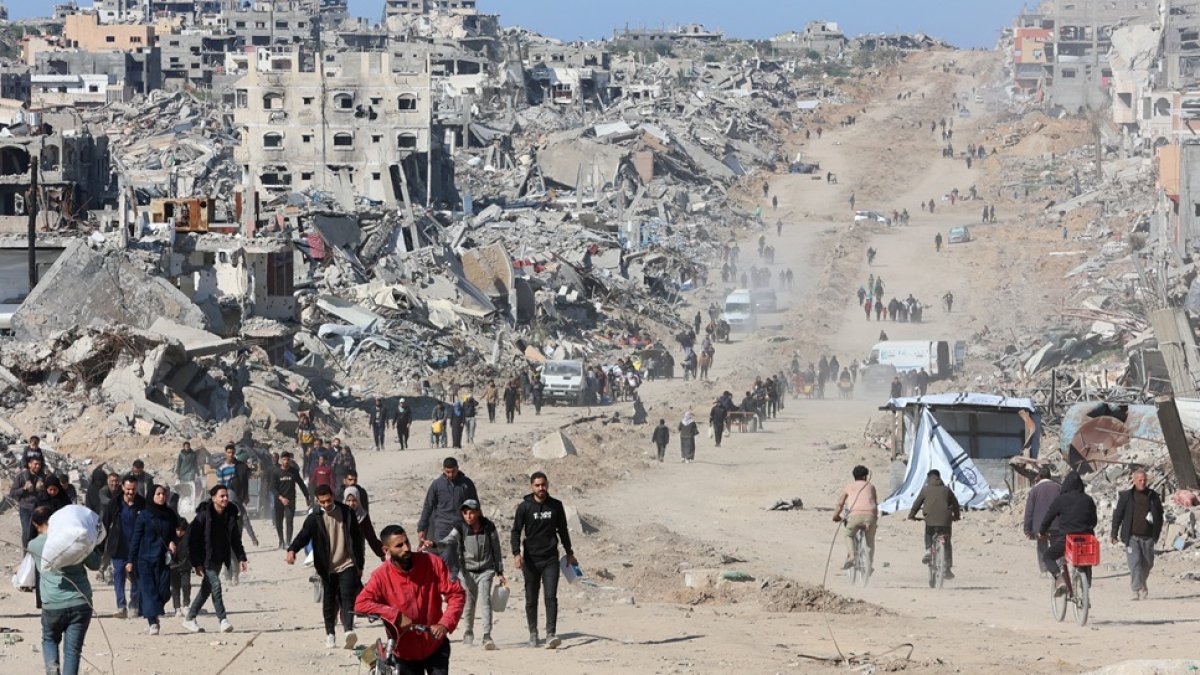 Palestinos caminan en una calle de Jabalia entre los escombros de edificios destruidos mientras los desplazados se dirigen a las zonas del norte de la Franja de Gaza.