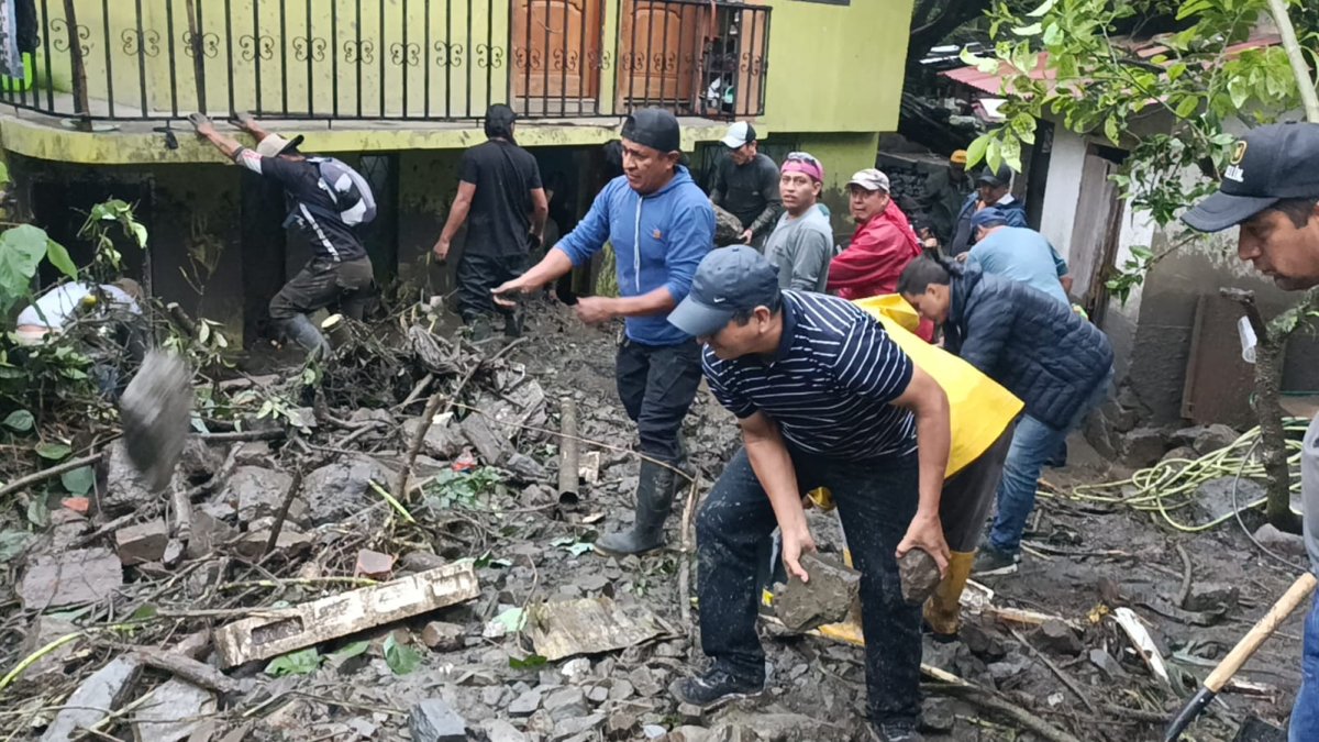 Vecinos del barrio Sacapo intentar remover el material pétreo tras el desbordamiento de una quebrada, este martes 21 de enero.