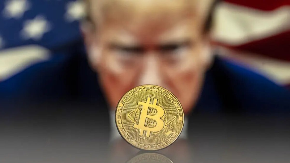 Referencial. Una ilustración de bitcoin, en una fotografía de archivo de Trump.