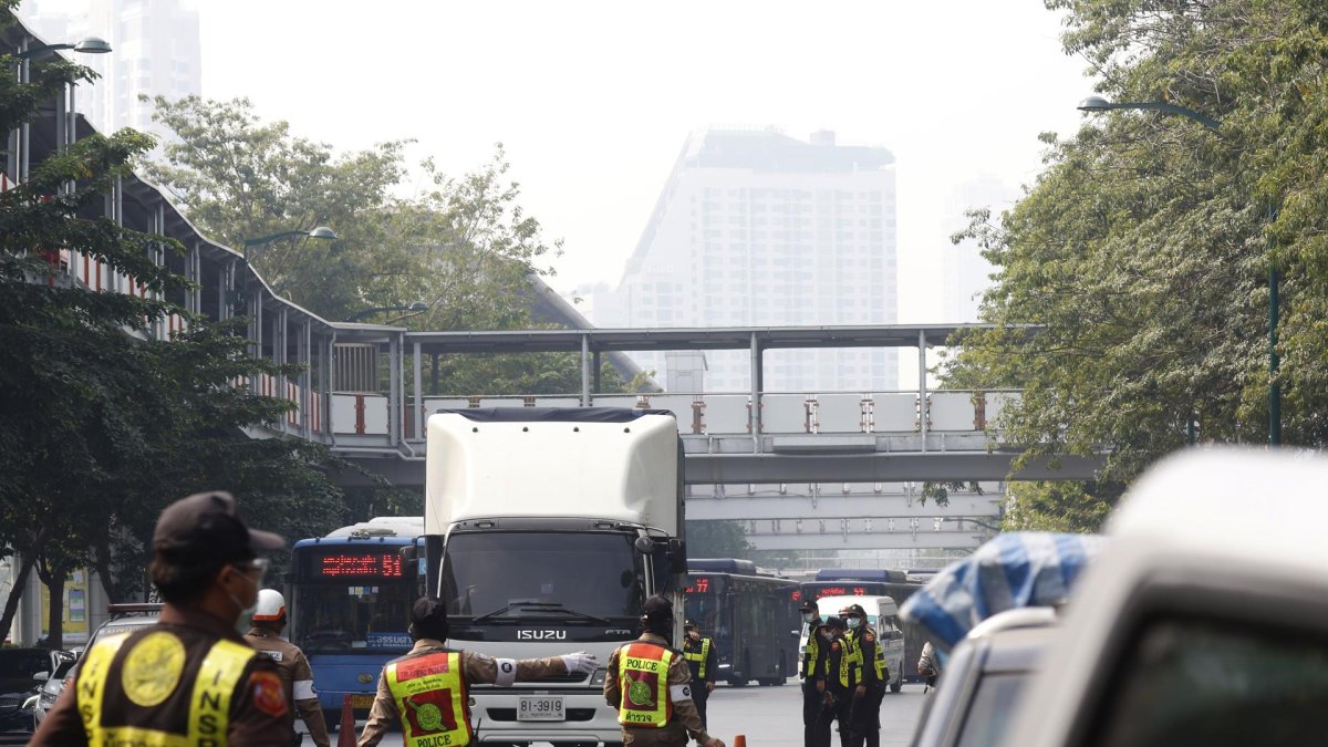 Los funcionarios de tránsito monitorean los vehículos en los puntos de control para detectar emisiones de humo como parte de una campaña de reducción de la contaminación en Bangkok