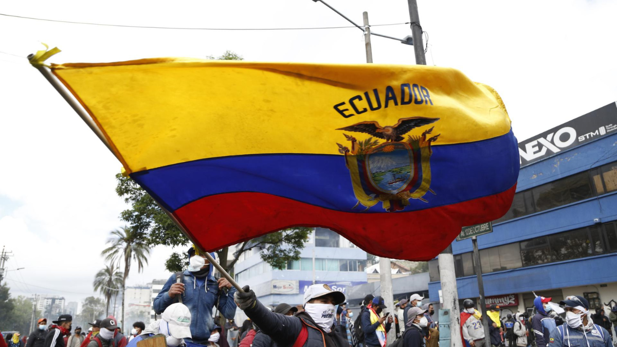 Fotografía de archivo en donde se ve a una persona que levanta una bandera de Ecuador.