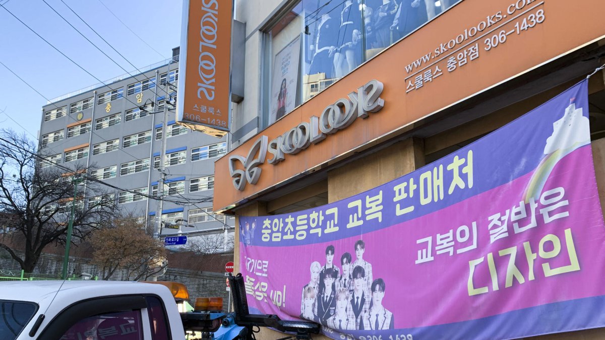 Una tienda junto al colegio Choongam anuncia la venta de uniformes escolares, cuya obligatoriedad ha rescindido la dirección de la escuela ante el acoso y los ataques que han sufrido sus alumnos.