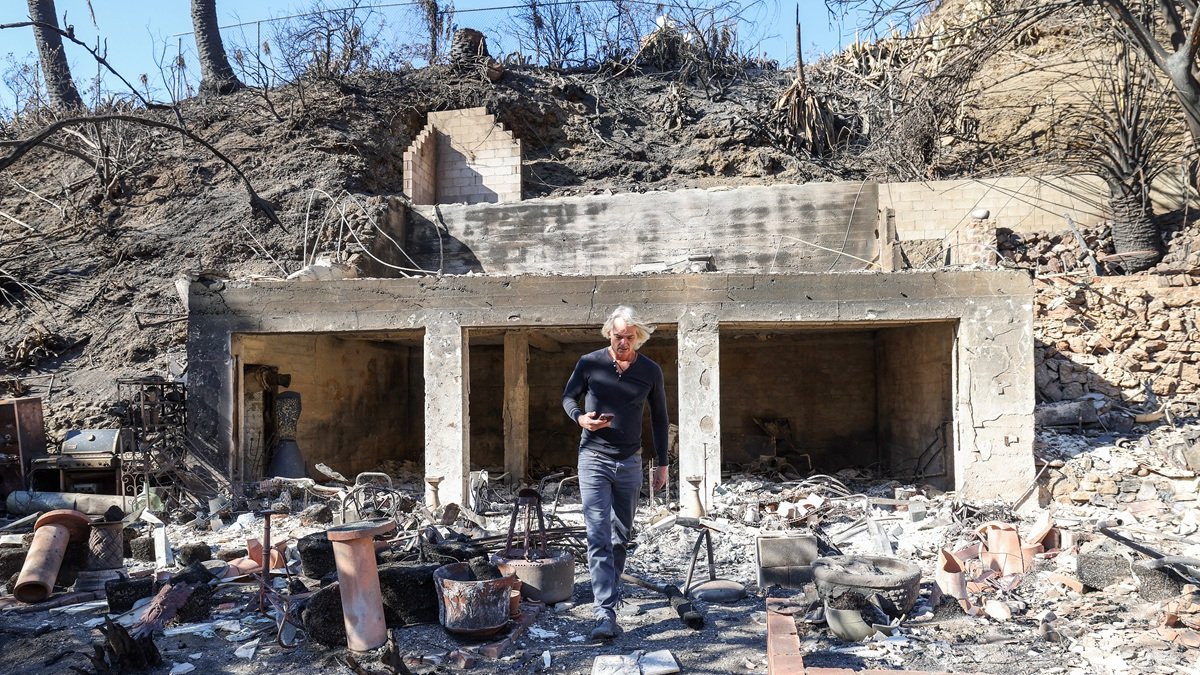 Sebastian Harrison examina las ruinas carbonizadas de su casa y sus anexos con vista al Océano Pacífico después del incendio de Palisades en Malibú, California, el 21 de enero de 2025.