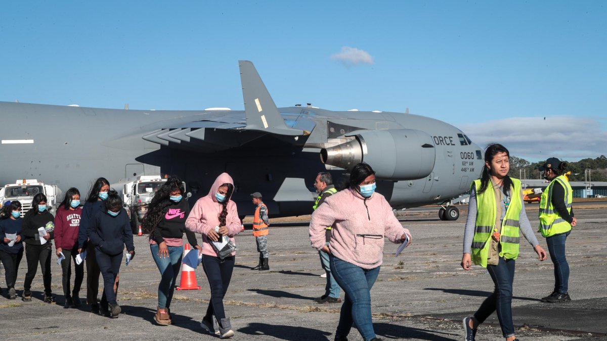 Un grupo de migrantes guatemaltecos deportados caminando por la pista de la Base Aérea de Guatemala, en Ciudad de Guatemala (Guatemala).