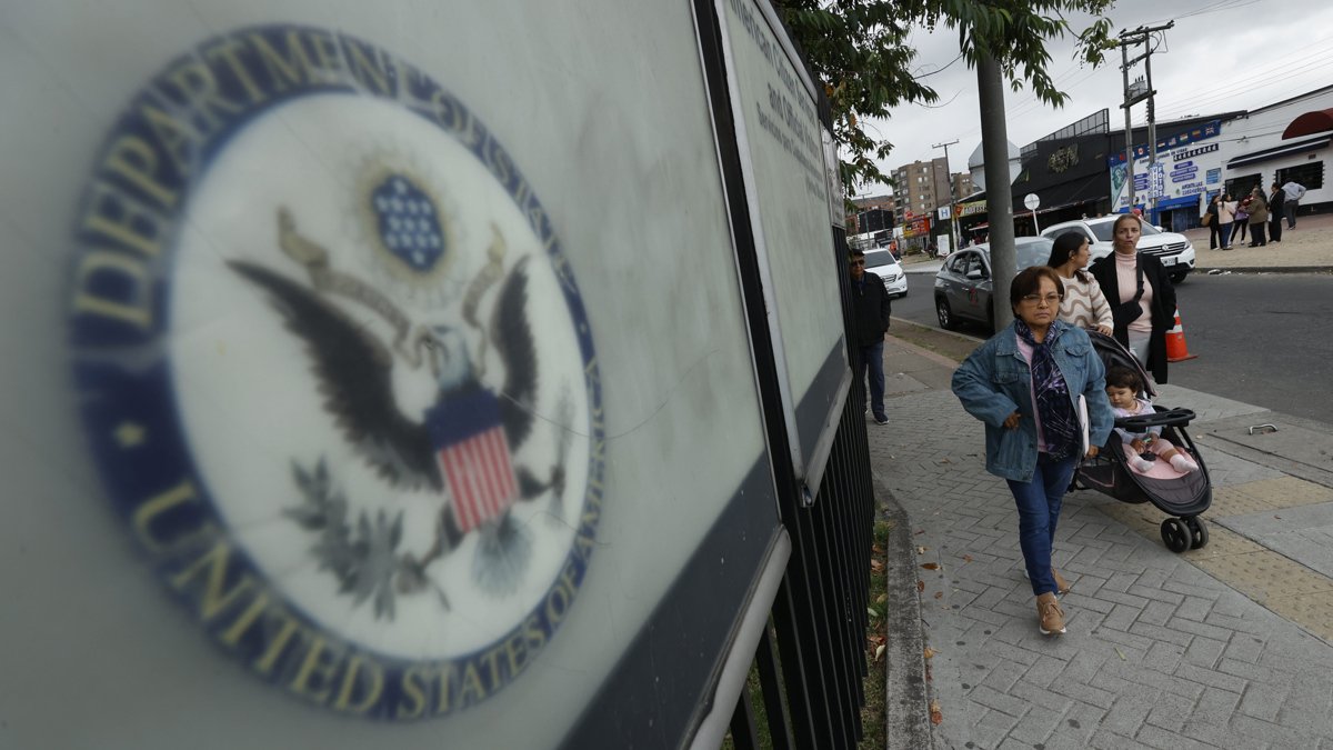Ciudadanos colombianos solicitantes de visa de los Estados Unidos caminan afuera de la embajada estadounidense este lunes, en Bogotá (Colombia).