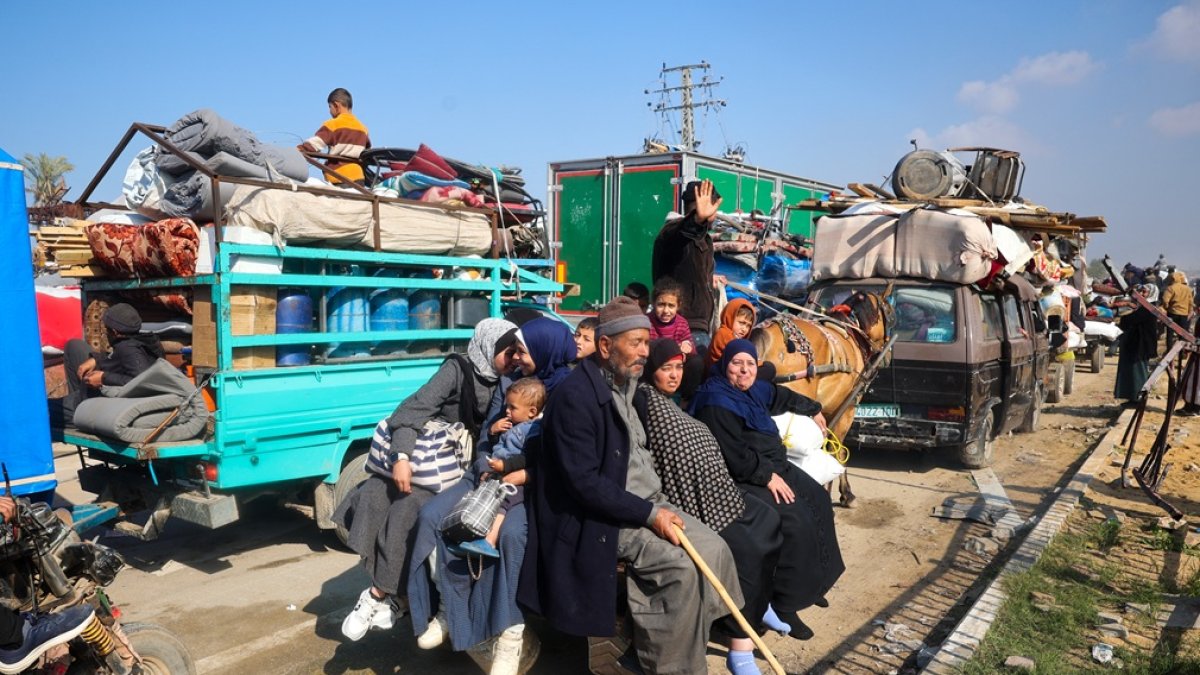Los desplazados viajan en la parte trasera de un carro tirado por caballos mientras cruzan el corredor de Netzarim desde el sur de la Franja de Gaza hacia la parte norte el 27 de enero de 2025.