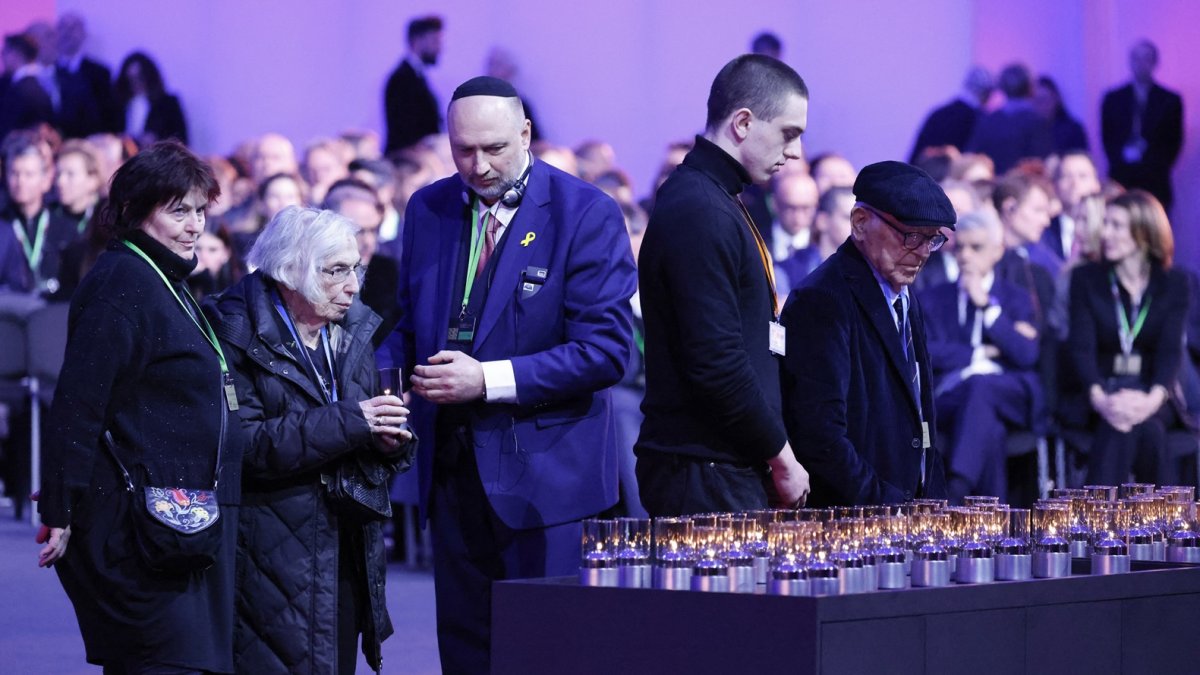 Los supervivientes llegan para colocar velas para rendir homenaje a las víctimas durante el 80º aniversario de la liberación del campo de concentración y exterminio nazi.