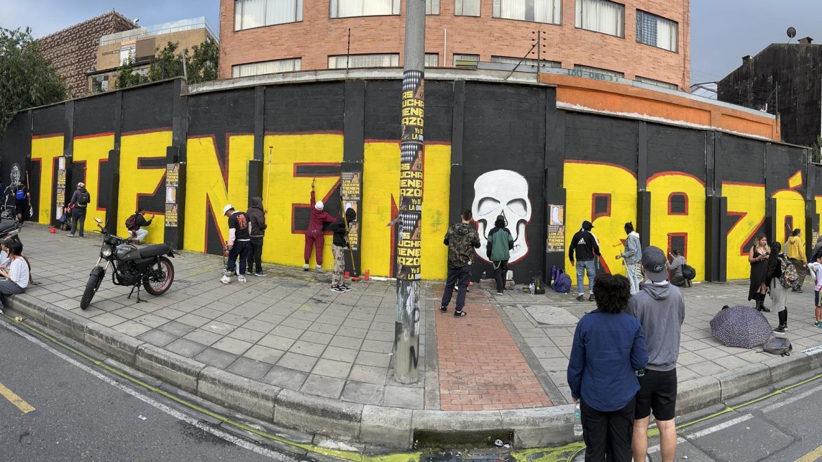 Foto panorámica de integrantes de colectivos artísticos pintando un grafiti este viernes en Bogotá (Colombia).