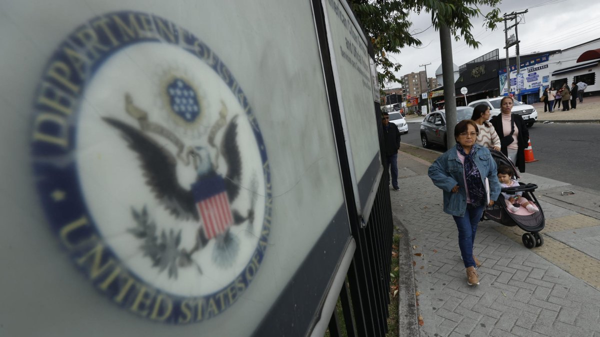 Varias personas cruzan cerca de la sede de la embajada de EE.UU. en Bogotá.