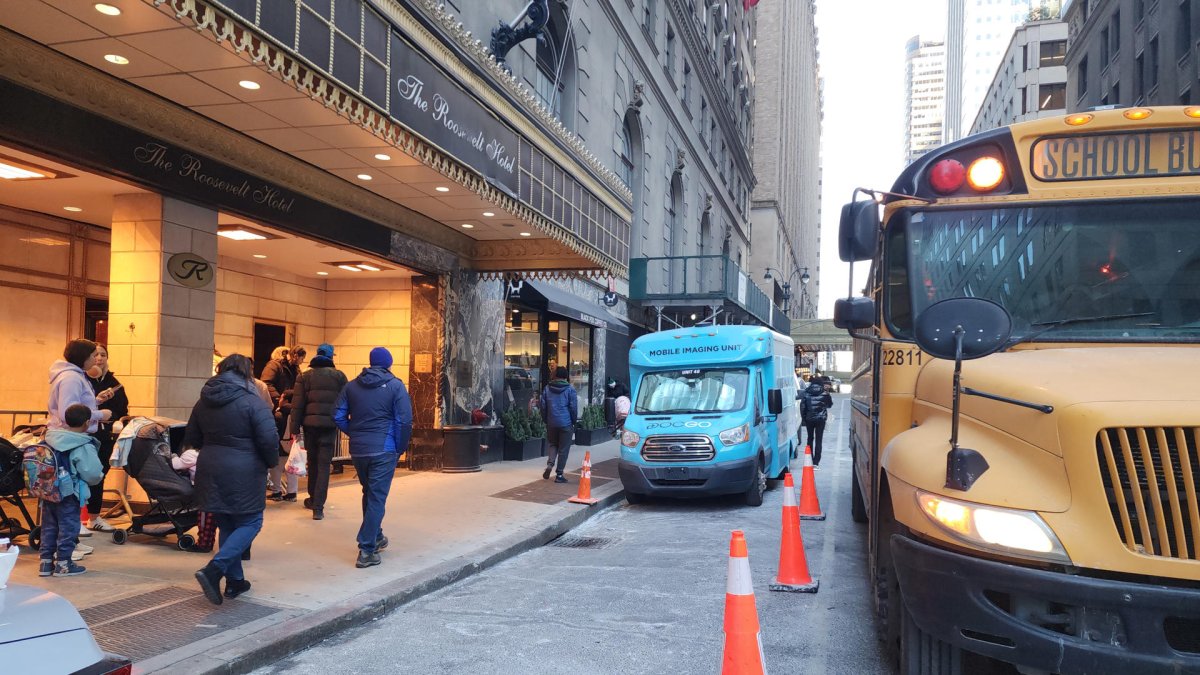 Padres esperan con sus niños al autobús escolar este lunes en Nueva York (EE.UU.).