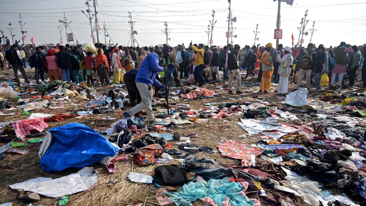Devotos caminan cerca de telas mezcladas en el suelo tras un accidente por estampida durante el festival Kumbh Mela cerca de Sangam Ghat Prayagraj, Uttar Pradesh (India).